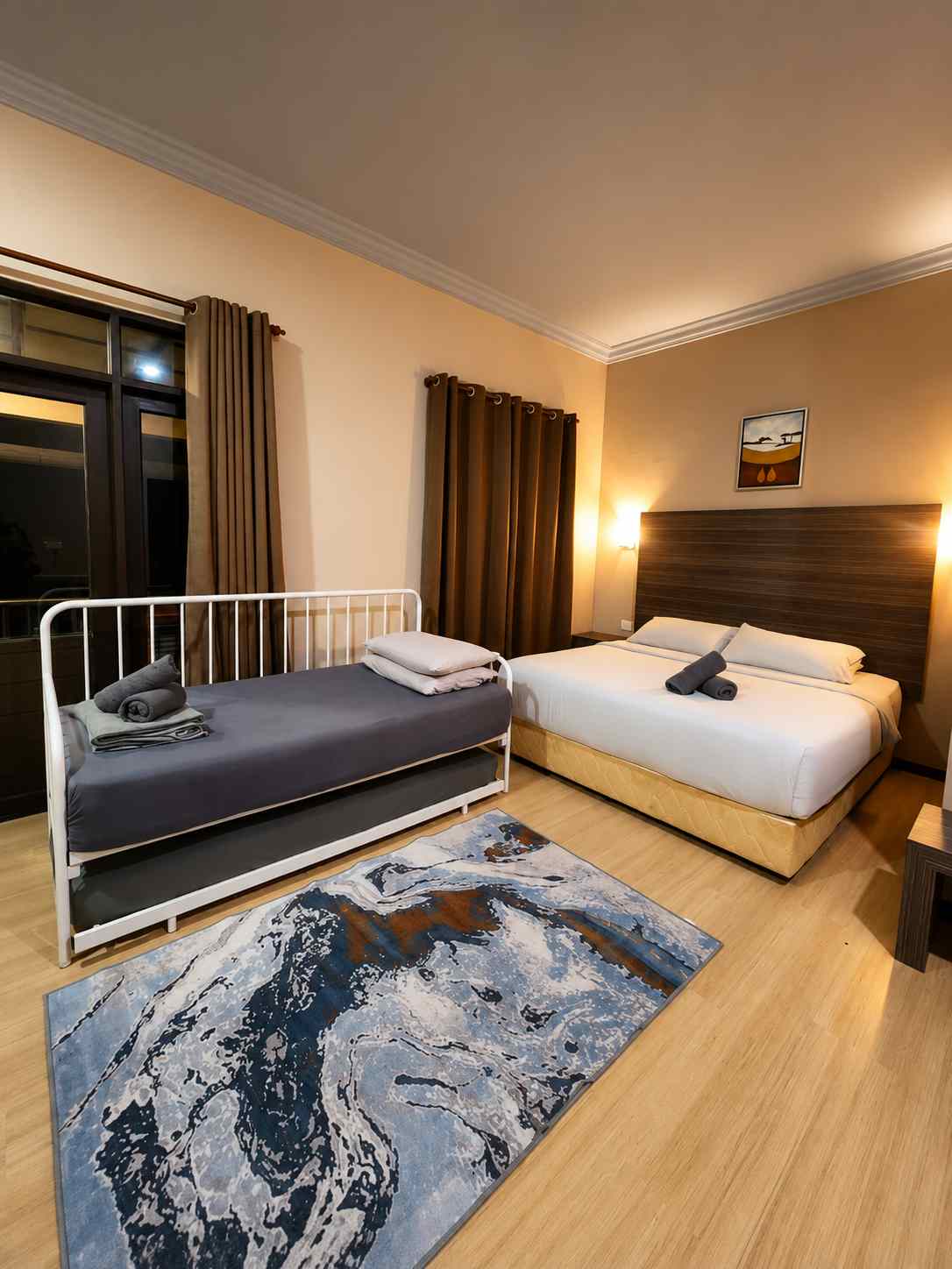 Bright, simple room interior with king bed, desk and tea tray